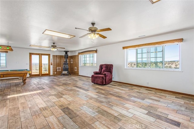 7045 Oak Hill Rd, Oak Hills, CA 92344 - unfurnished room featuring wood finished floors, a wood stove, a ceiling fan, and visible vents