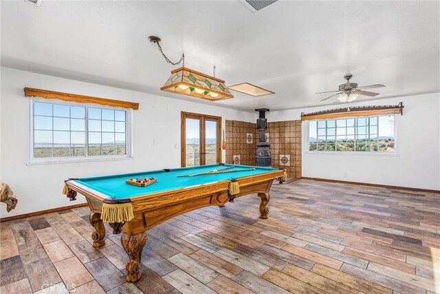 7045 Oak Hill Rd, Oak Hills, CA 92344 - rec room featuring a wood stove, wood finished floors, and baseboards