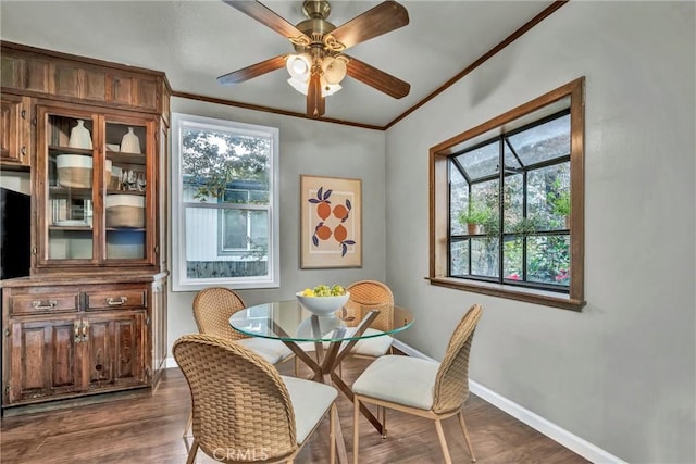 dining area with dark wood-style floors, baseboards, crown molding, and a healthy amount of sunlight