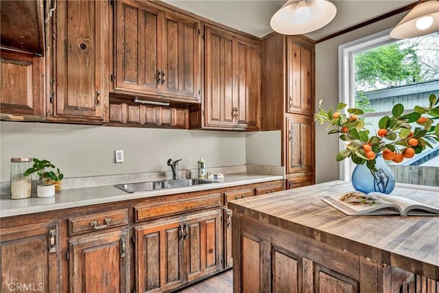 kitchen with a sink, butcher block countertops, and brown cabinetry