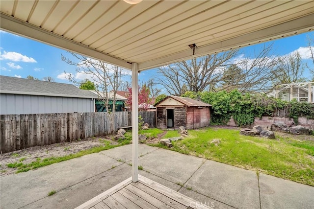 view of patio / terrace featuring a fenced backyard, an outbuilding, and a storage unit