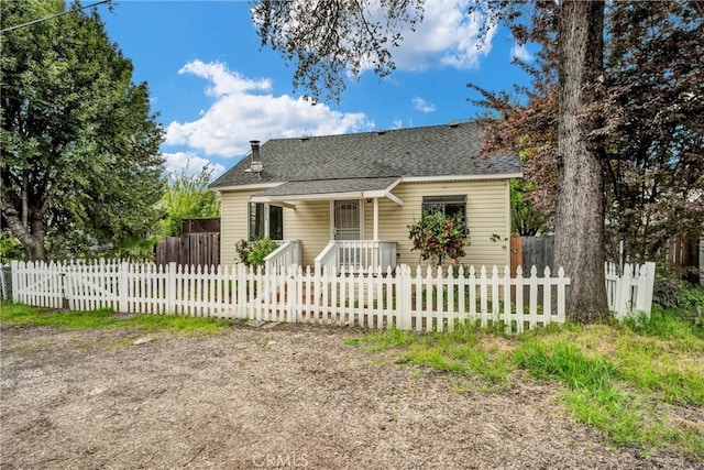 bungalow with roof with shingles, a porch, and a fenced front yard