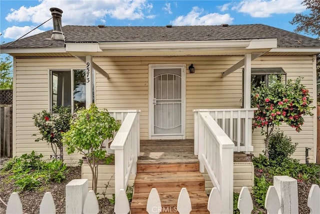 doorway to property with roof with shingles