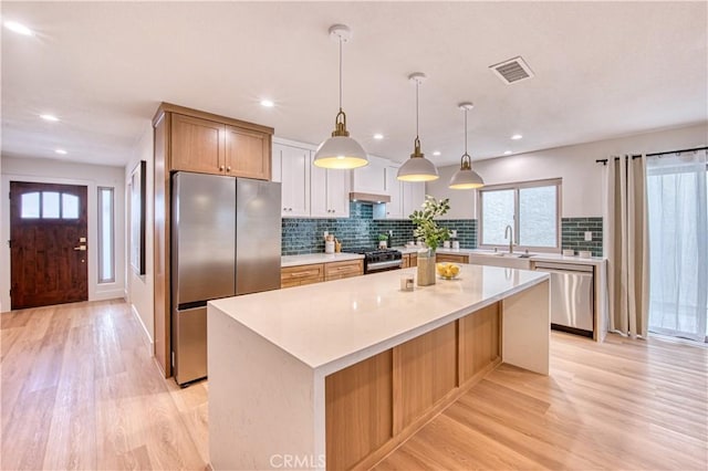 27695 Via Turina, Mission Viejo, CA 92692 - kitchen featuring stainless steel appliances, a center island, visible vents, and light wood-type flooring