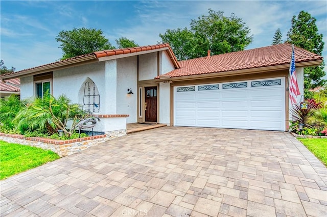 27695 Via Turina, Mission Viejo, CA 92692 - mediterranean / spanish-style house featuring a garage, a tiled roof, decorative driveway, and stucco siding