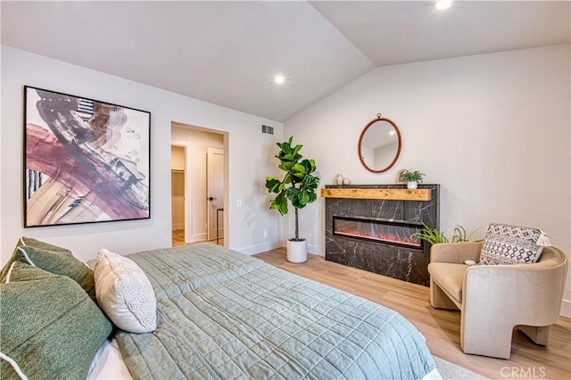 27695 Via Turina, Mission Viejo, CA 92692 - bedroom featuring visible vents, baseboards, a high end fireplace, vaulted ceiling, and wood finished floors