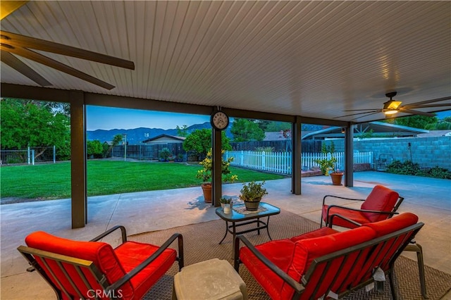 view of patio with ceiling fan, a fenced backyard, outdoor lounge area, and a mountain view
