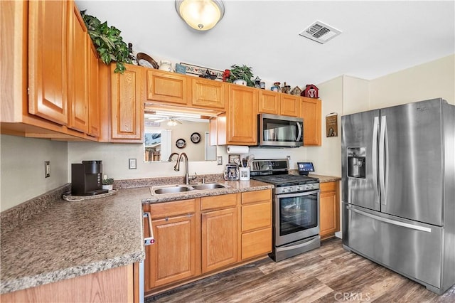 kitchen with a sink, ceiling fan, stainless steel appliances, dark wood-type flooring, and visible vents