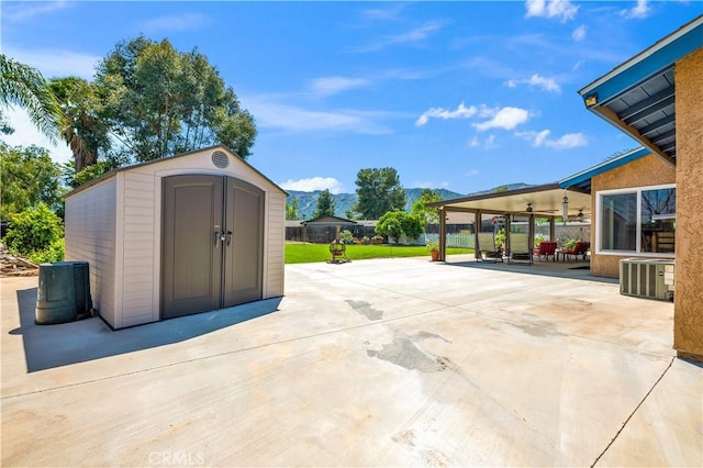 view of patio / terrace featuring central AC, a shed, a mountain view, an outbuilding, and ceiling fan