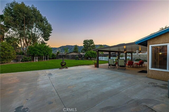 view of patio / terrace featuring a ceiling fan, a fenced backyard, and a mountain view