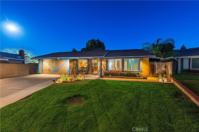ranch-style house featuring fence, driveway, and a front yard