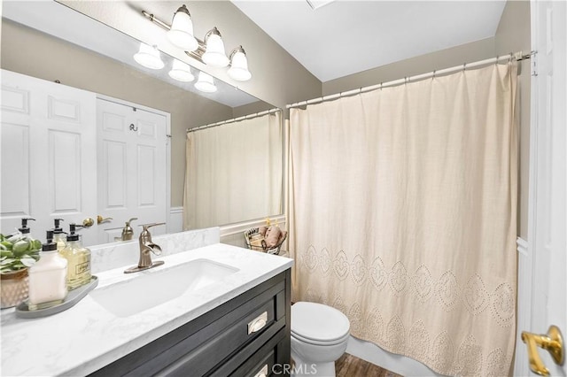 bathroom with toilet, vanity, and a shower with shower curtain