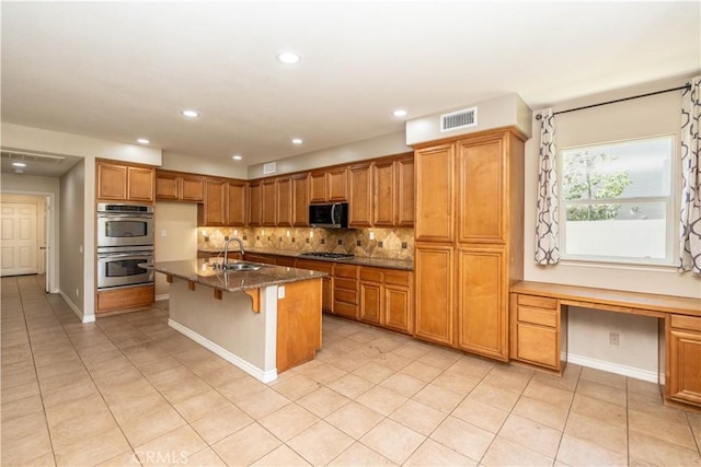 27321 Carlton Oaks St, Murrieta, CA 92562 - kitchen with visible vents, brown cabinets, decorative backsplash, stainless steel appliances, and a sink