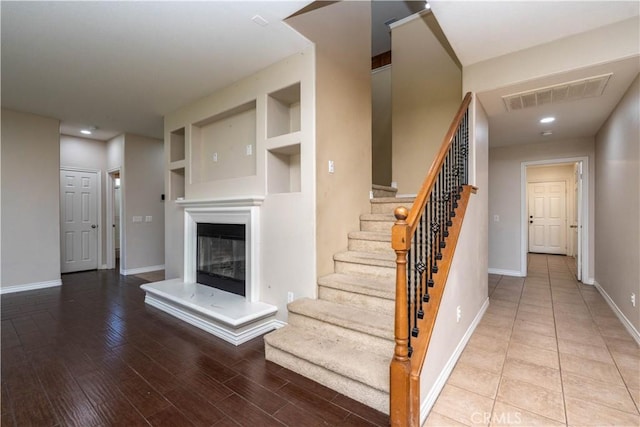 27321 Carlton Oaks St, Murrieta, CA 92562 - stairway with visible vents, baseboards, recessed lighting, wood finished floors, and a glass covered fireplace
