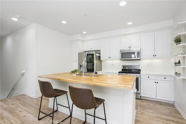 201 Native, Irvine, CA 92618 - kitchen featuring appliances with stainless steel finishes, open shelves, butcher block counters, white cabinets, and recessed lighting