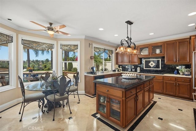 kitchen with a ceiling fan, brown cabinets, glass insert cabinets, backsplash, and ornamental molding