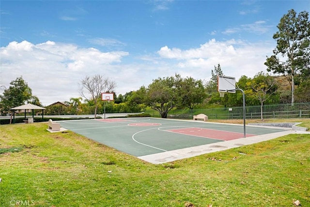 view of basketball court with a yard, community basketball court, and fence