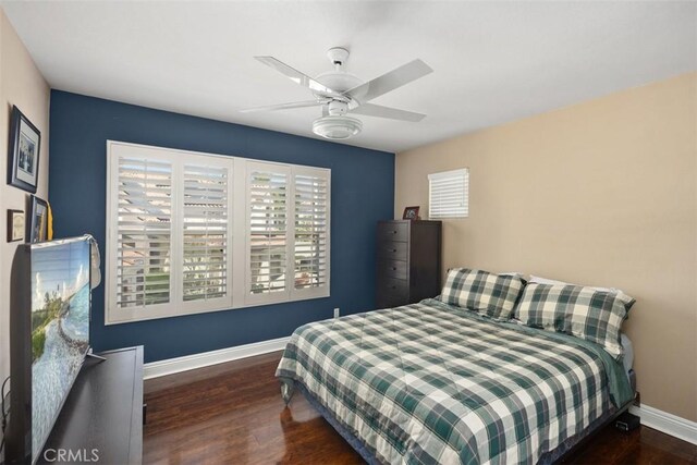 bedroom with wood finished floors, a ceiling fan, and baseboards