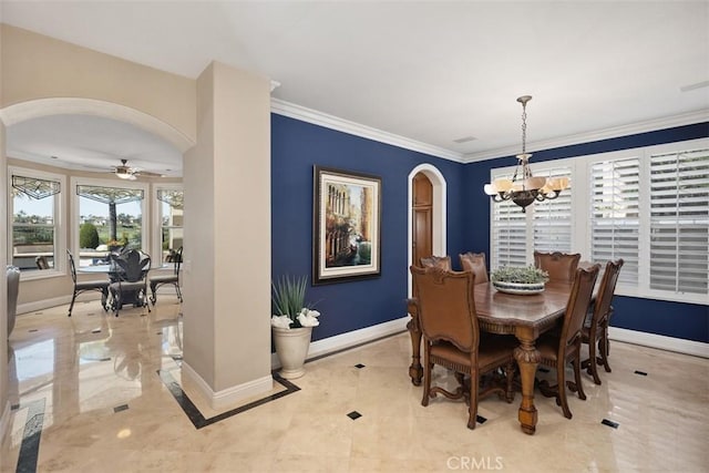 dining area with arched walkways, baseboards, ornamental molding, and ceiling fan with notable chandelier