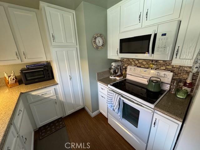 2 Via Pariente, Rancho Santa Margarita, CA 92688 - kitchen featuring white appliances, white cabinets, decorative backsplash, and dark wood-style flooring