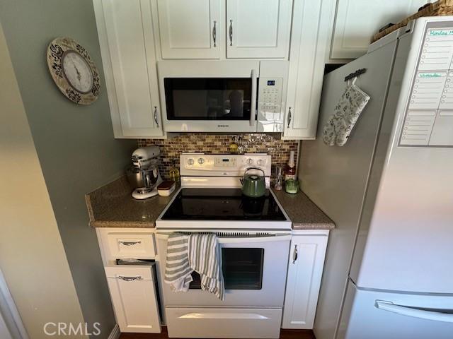 2 Via Pariente, Rancho Santa Margarita, CA 92688 - kitchen with white appliances, white cabinets, decorative backsplash, and dark stone countertops