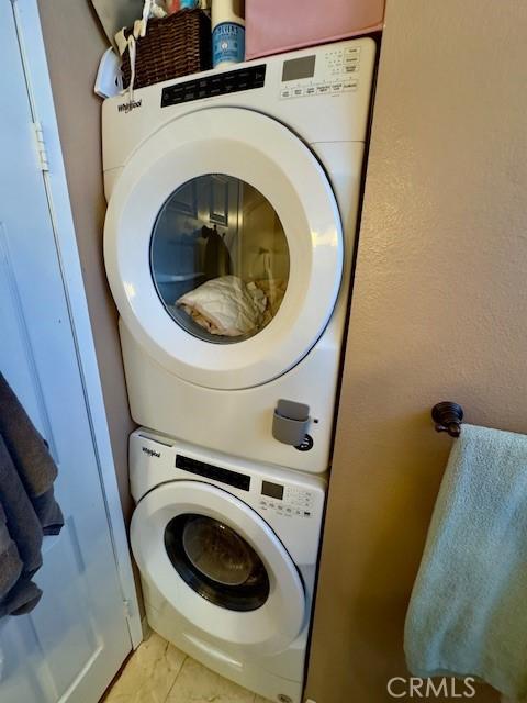 2 Via Pariente, Rancho Santa Margarita, CA 92688 - washroom featuring stacked washing machine and dryer and light tile patterned floors