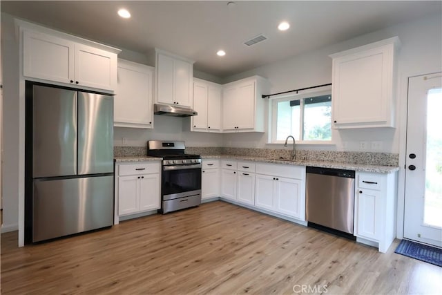 kitchen featuring a sink, white cabinets, stainless steel appliances, and under cabinet range hood