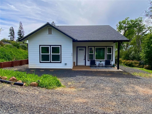 view of front facade with roof with shingles and covered porch