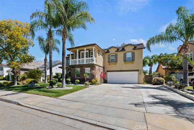 view of front of home featuring stucco siding, a balcony, driveway, a front lawn, and a garage