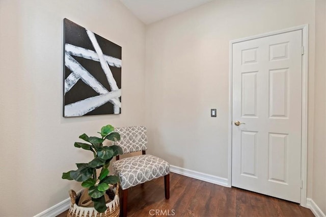 sitting room with baseboards and dark wood finished floors