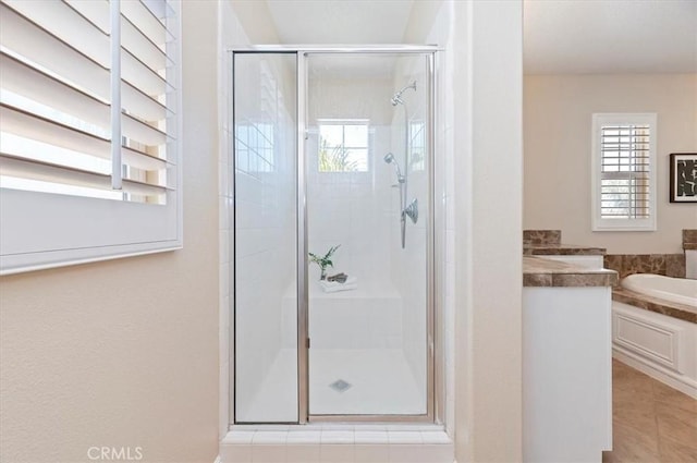 full bath with a shower stall, tile patterned flooring, and a bath