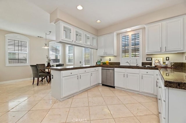 kitchen with a peninsula, dishwasher, and a healthy amount of sunlight