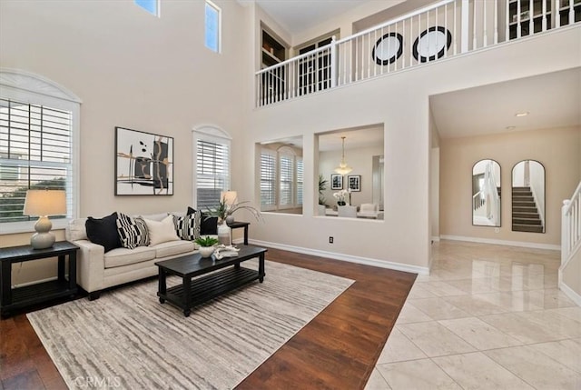 living area with baseboards, a high ceiling, and wood finished floors