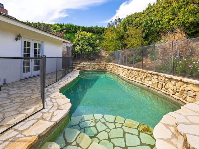 view of swimming pool with a patio, a fenced in pool, french doors, and a fenced backyard