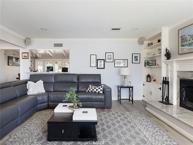 living room with ornamental molding, a fireplace, wood finished floors, and visible vents