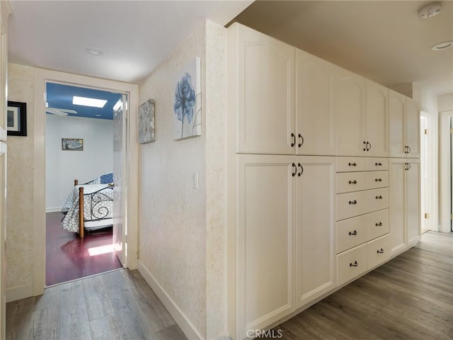 corridor with baseboards and dark wood finished floors
