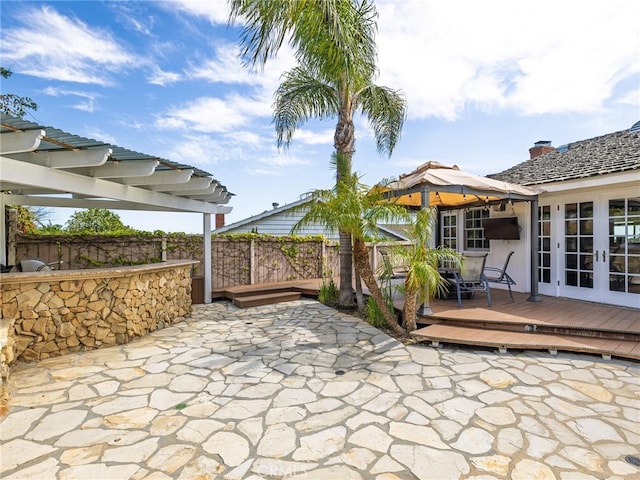 view of patio with a pergola, fence, french doors, and a deck