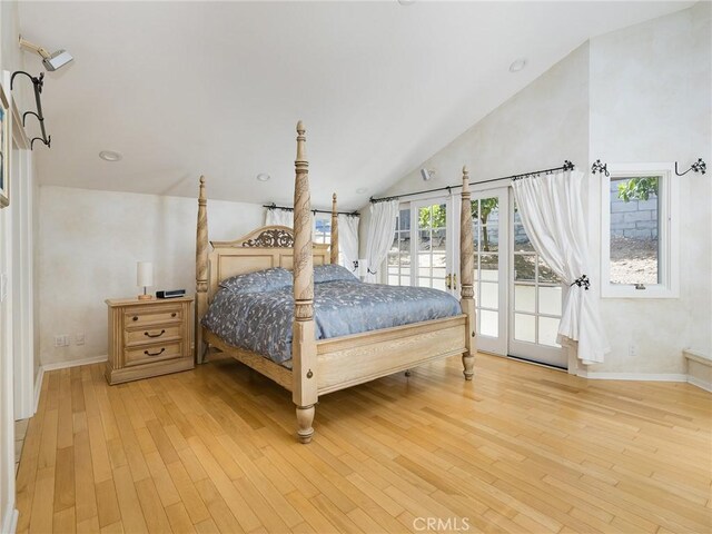 bedroom with baseboards, lofted ceiling, access to exterior, and light wood finished floors