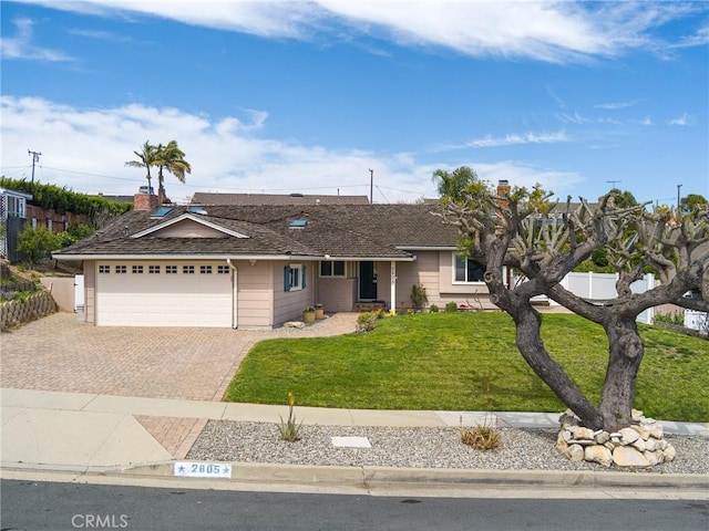 single story home featuring an attached garage, decorative driveway, fence, and a front yard