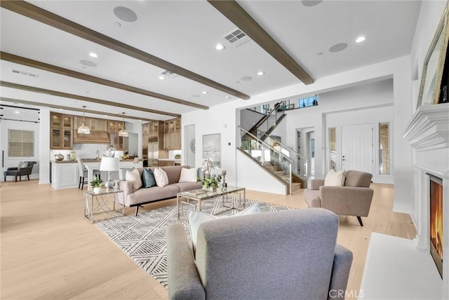 63 Poncho, Irvine, CA 92602 - living area with stairway, beamed ceiling, light wood-type flooring, a lit fireplace, and recessed lighting
