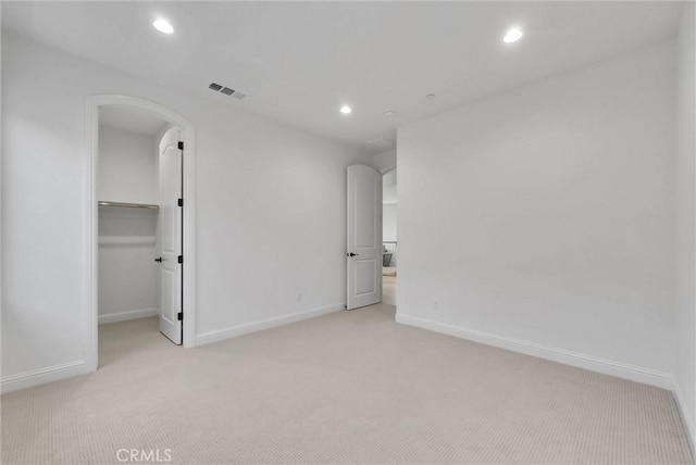 63 Poncho, Irvine, CA 92602 - unfurnished bedroom featuring light colored carpet, recessed lighting, a spacious closet, baseboards, and arched walkways