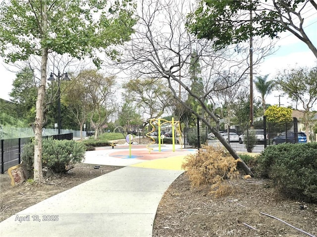 view of community featuring playground community and fence
