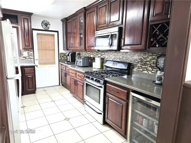 kitchen featuring glass insert cabinets, light tile patterned floors, wine cooler, stainless steel appliances, and backsplash