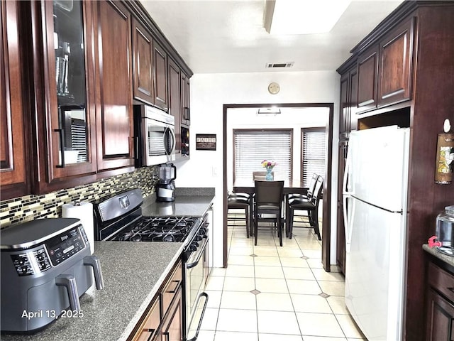 kitchen featuring dark countertops, visible vents, backsplash, and appliances with stainless steel finishes