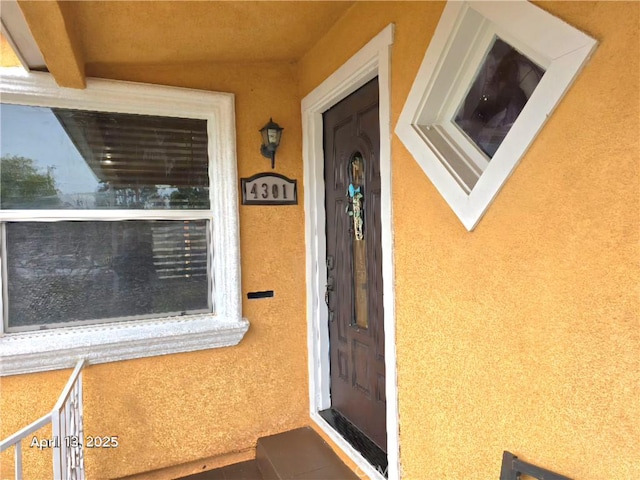 view of exterior entry with stucco siding