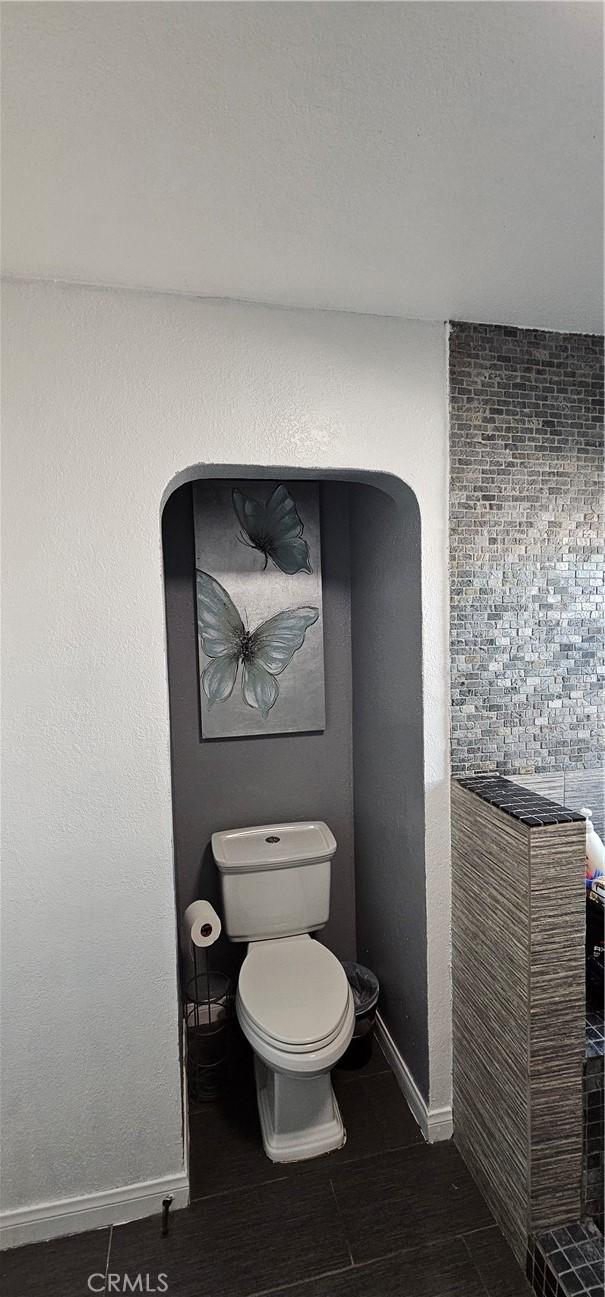 bathroom with tile patterned floors, toilet, and baseboards