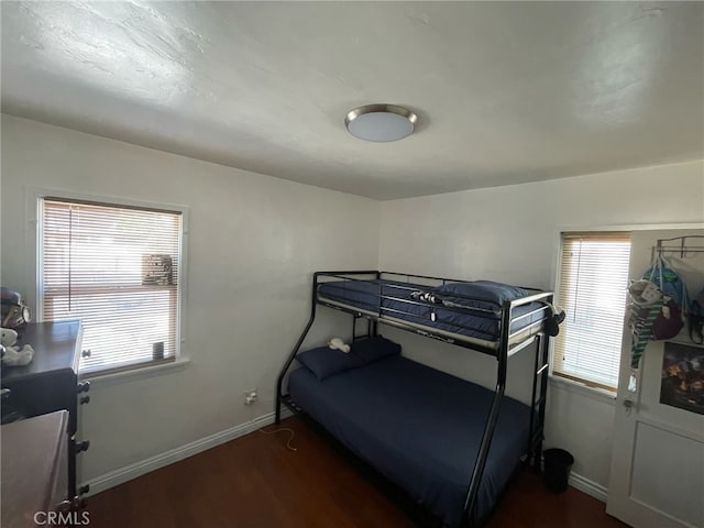 bedroom featuring baseboards and dark wood finished floors