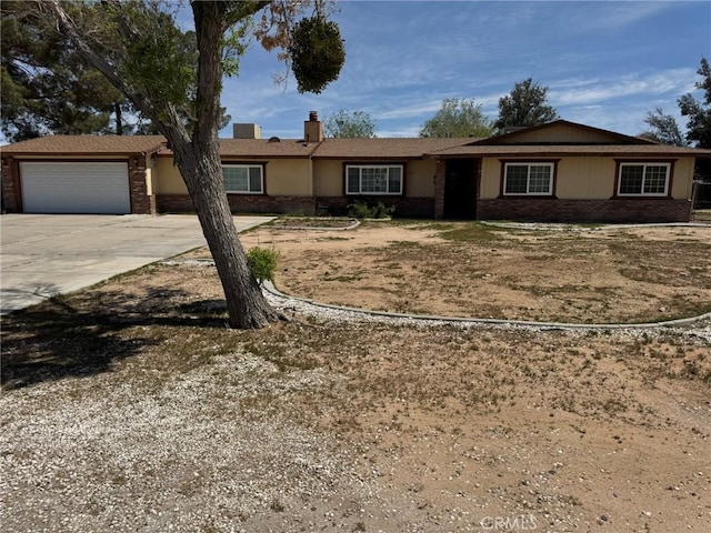13771 Wawona Rd, Apple Valley, CA 92307 - ranch-style home with concrete driveway, a garage, brick siding, and a chimney
