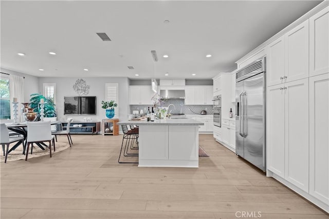 kitchen with stainless steel appliances, recessed lighting, and white cabinetry