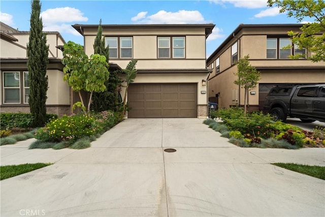 view of front of property with brick siding, an attached garage, driveway, and stucco siding